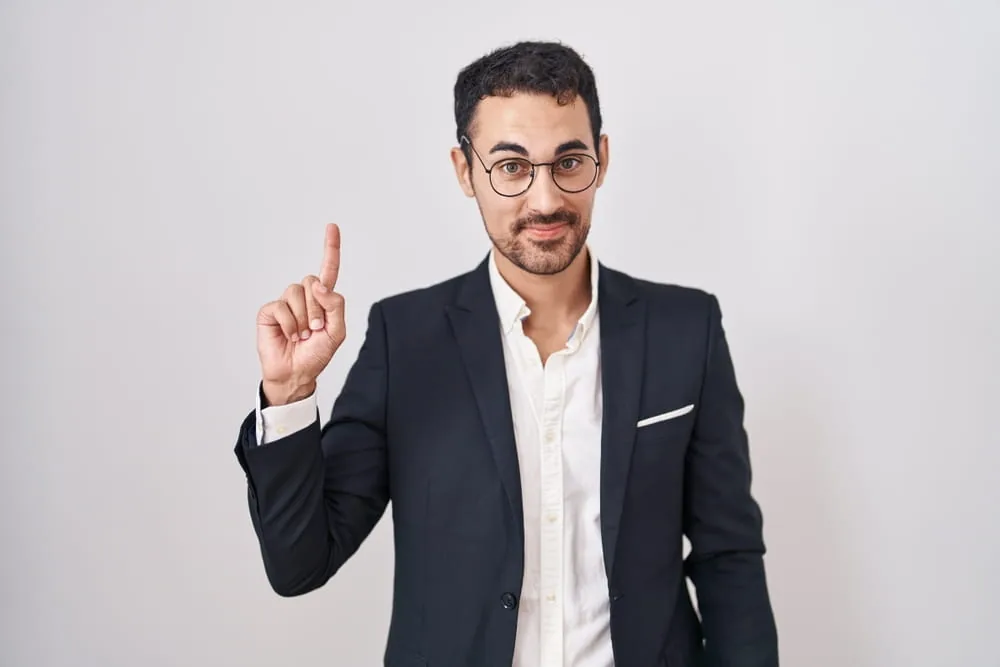 Mann im Anzug mit erhobenem Zeigefinger